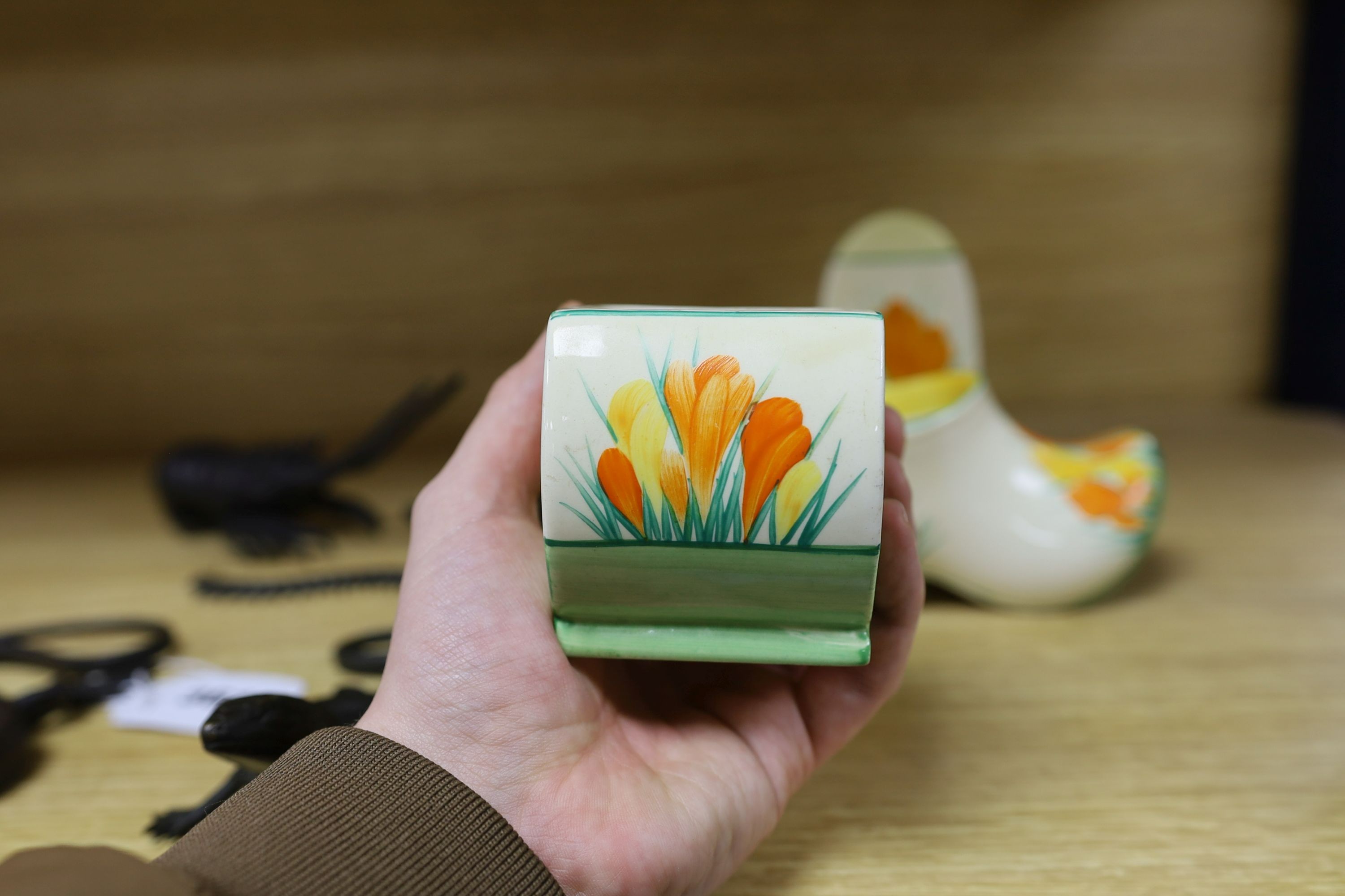 A Clarice Cliff sungleam crocus jam pot and cover, a sugar shaker and a Dutch clog ornament (3), jam pot and cover 10 cms high
